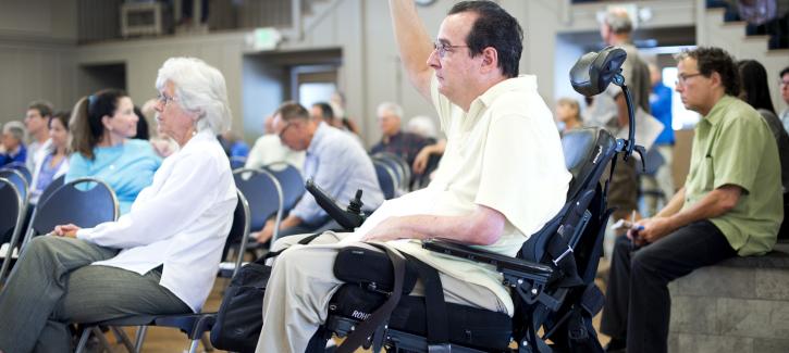 A man in a wheelchair raises his hand to ask a question at the Plan Bay Area 2040 open house in Marin County in 2016.